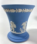 WEDGWOOD ENGLAND - VASO EM JASPER AZUL E BRANCO COM MOTIVOS DE PUTTINOS , MANUFATURA NO VERSO EM BAIXO RELEVO . MEDIDAS: 9 X 9 CM. CURIOSIDADES: EM 1738 COMEÇARAM AS ESCAVAÇÕES DE POMPEIA E HERCULANO PRÓXIMO DE NÁPOLES NA ITÁLIA CRIANDO A PARTIR DESSA ÉPOCA, NA EUROPA, UM NOVO INTERESSE AO ESTILO NEOCLÁSSICO. EM 1759, JOSIAH WEDGWOOD FUNDOU UMA MANUFATORA DE PORCELANA INSPIRADA EM MOTIVOS DA ANTIGUIDADE CLÁSSICA, TORNANDO SUA EMPRESA CONSAGRADA MUNDIALMENTE. AS PEÇAS ERAM REALIZADAS COM UM TIPO DE MATERIAL AO QUAL FOI DADO O NOME DE JASPER