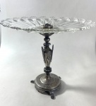 REFINADA CENTRO DE MESA, BASE EM METAL ESPESSURADO A PRATA E PRATO EM VIDRO TRANSLÚCIDO. MEDIDAS: 28 X 31 CM