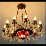 GRANDE LUSTRE PARA 12 LUZES , ESTRUTURA EM BRONZE, CRISTAIS  BACCARAT CÚPULA CENTRAL EM OVERLAY RUBI COM ADORNOS FLORAIS  E  BOBECHES; MEDIDAS:   70 X 70 CM APROXIMADAMENTE 3 PINGENTES FALTANTES.