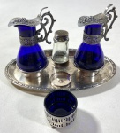 CONJUNTO PARA TEMPEROS EM METAL PRATEADO E VIDRO AZUL, UMA PEÇA É ADAPTADA E POSSUI BICADO NA BORDA. MEDIDAS: 13 X 23 CM