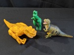 BRINQUEDO – Um lote contendo 3 dinossauros emburrachados, medindo 17x 30x 8cm (cinza) 38 x 12 x 8cm (vermelho) e 26x 38 x 8cm (verde).