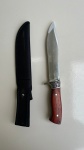 CUTELARIA - Faca Fulltang com punho em madeira e metal, com entalhes de arabesco. Lâmina lisa com aproximadamente 19cm. Acompanha bainha.