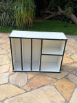 MÓVEIS - Estante em MDF na cor branca com acabamento preto, contendo divisórias verticais e 2 prateleiras laterais. Medidas aproximadas de 91x31x69cm. Produto sem portas, com marcas de uso, desgaste no acabamento e avaria nas quinas.