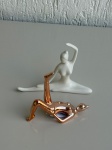 OBJETOS DECORATIVOS - Par de bailarinas decorativas em porcelana, sendo uma na cor dourada medindo aproximadamente 13x11cm e outra na cor branca medindo aproximadamente 16x13cm. Peças com acabamento brilhante, em bom estado geral.