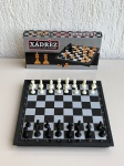BRINQUEDOS - Jogo de xadrez magnético, com tabuleiro dobrável que funciona como estojo para armazenamento das peças. Tabuleiro medindo aproximadamente 24,5cm, com peças plásticas imantadas. Acompanha caixa original. Item com marcas de uso, sinais no tabuleiro e desgaste na embalagem. Peças conforme fotos.