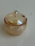 CRISTAIS - Açucareiro de cristal âmbar modelo Pearl, marca Wolff, com tampa e colher de plástico transparente. Mede aproximadamente 10x11cm. Peça em excelente estado (nova), com borda em relevo e acabamento translúcido.