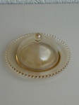 CRISTAIS - Queijeira de cristal âmbar modelo Pearl, marca Wolff, com tampa e colher de plástico transparente. Mede aproximadamente 20x9cm. Peça em excelente estado (nova).