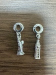 PRATA - LOTE COM 2 BERLOQUES EM PRATA 950, PANDORA, SENDO 1 DE ESTATUA DA LIBERDADE E OUTRO BIG BEN, PESO 6.4 GRAMAS.