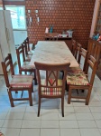 MESA COM 14 CADEIRAS- Uma mesa em mármore com os pés em formato de L em mármore Bahia, 14 cadeiras de madeira sendo 2 com braços e almofadadas e 12 cadeiras com 12 almofadas de assento que acompanham. medidno mesa 81 x 205 x 90cm, cadeira com braço 104 x 58,5 x 54 cm e cadeiras 93,5 x 43 x40,5 cm. Mesa com restauro na ponta.