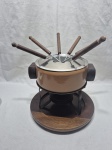 Panela de fondue em metal esmaltado com rechaud em metal, base e 6 espetos em madeira da Tropic art. Medindo a panela 16,5cm x 8cm de altura x 22cm de altura total.