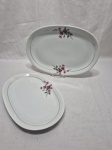 Par de travessas ovais rasas em porcelana Renner Medaillon com flor roxa e friso ouro. Medindo os dois tamanhos 34cm x 22,5cm e 29cm x 19,5cm.