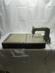 VINTAGE Máquina de costura vintage da marca Elna, modelo Grasshopper na cor verde oliva, acompanha base metálica original dobrável e alavanca de acionamento de joelho. Estado: Não acompanha o cabo de energia.