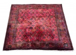 Tapete persa ISFAHAN, figuras policromadas sobre fundo vermelho com proteção de couro nas laterais e franja. Mede 2,15 x 2,10cm.