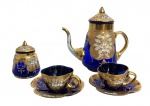 VENEZA - Conjunto de café em cristal veneziano na cor azul cobalto, ricamente decorado com douração e pintura floral policromada. Composto por cafeteira com tampa, açucareiro com tampa e duas xícaras com pires de bordas recortadas. Peças de apelo decorativo, em bom estado geral. Medida do maior 18 cm.