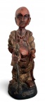 AFRICA - Escultura em madeira representando figura humana de caráter étnico/oriental, possivelmente monge ou personagem ritualístico, com policromia em tons terrosos. A figura segura serpente, com entalhe expressivo e base decorada. Peça de forte presença decorativa e coleção. Marcas do tempo. Mede 38 cm altura.