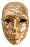 Máscara para parede em faiança europeia esmaltada com acabamento iridescente em tons dourados, apresentando reflexos nacarados. Modelo facial clássico, de estética teatral/veneziana, própria para decoração de parede. Mede 18 x 13 cm.