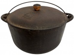 Panela antiga em ferro fundido, com tampa original e alça móvel em metal. Apresenta pegador em madeira e marca em relevo na tampa Panela de Vovó  A legítima. Peça robusta, de uso tradicional, com pátina do tempo que valoriza seu caráter rústico e decorativo. Mede 34cm x 18cm.
