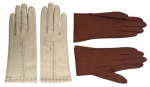 Lote composto por dois pares de luvas antigas em couro, sendo um em tonalidade clara e outro em marrom. Modelos clássicos, de punho médio, com acabamento costurado e detalhes decorativos no dorso. Apresentam sinais de uso e pátina do tempo, conferindo caráter e autenticidade às peças. Medida da maior 25cm.