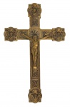 Importante cruz processional de parede em metal dourado, ricamente ornamentada com relevos em estilo neogótico, apresentando figura de Cristo crucificado e terminações com cabeças de querubins alados. Verso com argola para fixação e marca Dourado. Peça decorativa de forte caráter sacro e expressiva presença ornamental. Mede 17cm x 27cm.