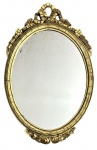 Espelho oval de parede em madeira entalhada e dourada, com delicados elementos florais e ornamentação vazada no coroamento, possivelmente trabalho europeu do século XIX/XX em estilo clássico. Espelho antigo com sinais naturais do tempo e oxidação no cristal, conferindo charme e autenticidade à peça. Mede 80cm x 51cm.
