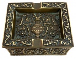 Elegante cigarreira/caixa porta-charutos em metal dourado, ricamente ornamentada em relevo com motivos vegetalistas e ânfora central, seguindo influência neorrenascentista. Tampa articulada com assinatura Barbelos  Lisboa. Peça de forte caráter decorativo e acabamento refinado. Mede 10,5cm x 8,5cm.