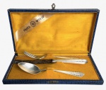 Faqueiro infantil antigo da tradicional Prata Wolff, composto por colher, garfo e faca em alpacca, com monogramas gravados. Acompanha elegante estojo original revestido externamente em padrão imitando couro. Peças de desenho clássico e delicado, ideais para coleção ou decoração. Medida do maior 18cm.