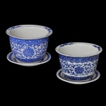 Par de pequenos cachepot com seu presentoir, em porcelana chinesa, azul índigo e branca. Apresenta um padrão floral, com folhagens e volutas intrincado. Decoração em azul índigo sobre fundo branco com motivos de flores, folhagens e volutas. 11 x 15 cm. 16 cm (presentoir).
