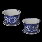 Par de pequenos cachepot com seu presentoir, em porcelana chinesa, azul índigo e branca. Apresenta um padrão floral, com folhagens e volutas intrincado. Decoração em azul índigo sobre fundo branco com motivos de flores, folhagens e volutas. 11 x 15 cm. 16 cm (presentoir).