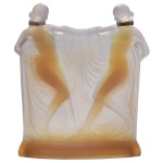 SABINO. "Double Suzanne". Grupo escultórico de vidro opalescente criado por Marius-Ernest Sabino por volta de 1930 na França. Duas figuras femininas nuas dançando, segurando um xale drapejado. O design é inspirado na famosa estatueta individual "Suzanne" feita pelo contemporâneo René Lalique. Vidro opalescente moldado e prensado. Apresenta tons quentes cor de mel/âmbar quando iluminado por trás e reflexos azulados sob luz frontal. 22 x 19 cm. As figuras apresentam colares de prata no pescoço.