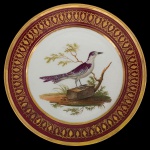 PRINCIPE DE JOINVILE - Prato em porcelana francesa, Século XIX, sem marca. Borda dourada e vermelho escuro com representação de renda em dourado. Centro com pássaro e ramos. 22 cm. Reproduzido a página 219 do livro Louça da Aristocracia no Brasil.