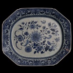 CHINA. Séc. XVIII - Travessa em porcelana chinesa. Formato octogonal com bordas decoradas em padrões geométricos em azul e branco com motivos florais ao centro. 45 x 38 cm.