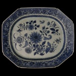 CHINA. Séc. XVIII - Travessa em porcelana chinesa. Formato octogonal com bordas decoradas em padrões geométricos em azul e branco com motivos florais ao centro. 45 x 38 cm.
