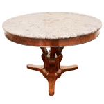 Séc. XIX  Mesa de centro ou de apresentação em madeira nobre (mogno). Apresenta forte influência do design Império do século XIX. Superfície redonda em mármore trabalhado com veios naturais claros e escuros. Saia cilíndrica profunda conectada a três pernas recurvas proeminentes. Coluna central robusta que se une a uma base tripoidal recortada e nivelada. 73 x 110 cm.