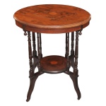 Séc. XIX - Mesa lateral em madeira nobre, estilo inglês, vitoriano. O tampo circular principal apresenta um motivo central marchetado estilizado em formatos como conchas ou estrelas geométrico florais com filetes de madeira mais clara que delimitam a borda externa. Possui uma prateleira ou "tier" inferior redonda também decorada com marchetaria combinando com o topo. O tampo é sustentado por um conjunto de pernas finas e torneadas que se unem a uma base arqueada. Fabricada em madeiras nobres valorizadas pelo padrão de seus veios naturais acentuados, exibindo uma rica pátina envelhecida. 71 x 61 cm.