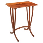Mesa lateral original do período Art Nouveau, apresentando um tampo marchetado com uma paisagem de camelo, similar a obras de Émile Gallé. O tampo retangular apresenta um trabalho detalhado em marqueterie feito com diferentes tipos de lâminas de madeiras nobres. As pernas longas e esguias ramificam-se graciosamente em direção ao tampo e terminam em pés curvados para fora, interligados por uma travessa arqueada que reforça a fluidez das linhas naturais e orgânicas77 x 60 x 40 cm