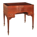 Importante Dressing Table em madeira nobre (mogno) de época Edwardiana / George V, Penteadeira mecânica com abertura superior em estilo Beau Brummell. A tampa superior é articulada. Ao ser aberta, aciona um sistema que eleva espelhos chanfrados em tríptico e revela compartimentos organizadores internos. Estrutura em mogno maciço com marchetaria e filetes de buxo (boxwood). Pernas cônicas e delgadas que terminam em rodízios de latão, facilitando a movimentação. 97 x 89 x 57 cm (fechada) 154 x 89 x 57 cm (aberta). Apresenta sinais de uso e do tempo (risco no tampo e algumas leves manchas). Espelho bisotê com duas gavetas. 8 escovas (24 x 14 cm maior), 2 potes para algodão, 4 perfumeiros, 4 potes (2 sem tampa), 2 potes e 1 espelho.