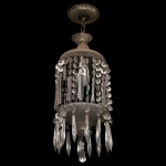Lustre contemporâneo em cristal no formato de gaiola cilíndrica, com uma luz central. Cúpula superior encimada por adornos cônicos, com borda sustentando colares e pingentes lapidados. Parte inferior com prato circular fundo moldado com finos gomos, bordado por rosetas e pendentes, seguindo o estilo. Acompanha uma corrente metálica central interligada a uma canopla superior trabalhada em vidro ou cristal para acabamento junto ao teto. 70 x 20 cm.