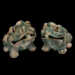 Par de pequenas esculturas em porcelana chinesa no formato de sapos. Apresentam cobertas malhadas verde claro e marfim. 13 x 18 x 11 cm. Peças modernas e decorativas.