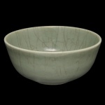 Bowl circular fundo em porcelana chinesa, revestido por coberta celadon de cor esverdeada com craquelê do tipo Guan. Apresenta marca apócrifa em escrita arcaica sob a base. Séc. XIX. 14 x 33 cm.
