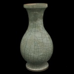 CHINA. Séc. XVIII / XIX - Vaso balaústre em porcelana chinesa, revestido por coberta celadon de cor esverdeada com craquelê do tipo Guan. Bojo abaulado, encimado por gargalo em corneta e borda saliente. Base circular e retraída. Resquício de etiqueta sob a base. 42 x 22 cm.