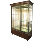 Cristaleira ou vitrine clássica em madeira com portas de correr e prateleiras internas de vidro. Base sólida e cornija superior robusta em madeira nobre escura. Painéis frontais deslizantes de vidro que otimizam o espaço na abertura. Divisórias em vidro temperado transparente com suportes discretos para manter a leveza visual. Laterais também envidraçadas que favorecem a entrada de iluminação natural e o destaque dos objetos expostos. Esse tipo de mobiliário é ideal para expor cristais, coleções, louças com total visibilidade, combinando uma estrutura robusta de madeira na base e no topo com fechamentos laterais e frontais inteiramente em vidro translúcido. 235 x 153 x 50 cm. Este lote encontra-se no  Jardim Europa, SP., não desce pelo elevador, precisa ser içado. e deverá ser retirado no local com agendamento prévio e antecedência, no nosso escritório do leilão. Telefone 11.5044.1228