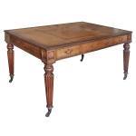 Escrivaninha antiga estilo parceiro ("partners writing table") do período William IV / Regência, fabricada na Inglaterra por volta da década de 1830. Construída em madeira de mogno maciça de alta qualidade com um acabamento clássico em pátina quente.  Superfície retangular com cantos suavemente arredondados, revestida em couro legítimo envelhecido com detalhes em relevo nas bordas. Configuração de mesa dupla ("partners table"), apresentando gavetas funcionais em ambos os lados para que duas pessoas possam utilizá-la simultaneamente frente a frente. Possui puxadores de latão decorativos em estilo roseta. Quatro pernas retas finamente torneadas e caneladas, que se estendem até a base apoiadas sobre rodízios originais de latão para facilitar a movimentação. Tampo manchado conforme foto ilustrativa. 80x 150 x 98 cm. Uma gaveta com puxador solto. Este lote encontra-se no  Jardim Europa, SP., não desce pelo elevador, precisa ser içado. e deverá ser retirado no local com agendamento prévio e antecedência, no nosso escritório do leilão. Telefone 11.5044.1228