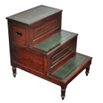Séc. XIX - Escada de biblioteca antiga estilo George IV / Regência Inglesa, confeccionada em madeira nobre por volta do século XIX. Estrutura em mogno maciço com degraus revestidos de couro texturizado e decorado com gravação dourada (gilt-tooled leather).Peças dessa época frequentemente possuem dupla função; o degrau superior ou do meio costuma levantar-se ou deslizar para revelar um compartimento interno de armazenamento (historicamente usado como baú ou até mesmo penico de quarto). Apresenta pernas torneadas clássicas da era georgiana e regência britânica. 70 x 53 x 70 cm.