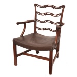 Cadeira de braços (tipo carver) com encosto de escada (ladderback), feita de mogno no estilo tradicional Chippendale Irlandês. Trata-se de uma peça de qualidade do período de revivalismo (produzida por volta de 1940), Possui réguas horizontais vazadas e onduladas (pierced ladder back), encimadas por terminais esculpidos que lembram as clássicas "orelhas Chippendale. Os braços de madeira são suavemente curvados e terminam em volutas esculpidas. A estrutura inferior conta com pernas quadradas unidas por travessas em formato de "H" para maior estabilidade. O assento é estofado em couro marrom envelhecido, finalizado com acabamento em tachas metálicas ao longo da borda. 97 x 68 x 53 cm.