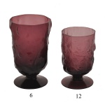 Conjunto de 18 copos com pé circular em vidro na cor ametista. Apresenta uma textura rugosa e orgânica simulando um efeito amassado ("crinkle"). Sendo: 6 taças (14 cm) e 12 taças (11 cm).