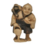 JAPÃO, Netsuke, em marfim policromado, representando um homem sorridente com um pequeno animal, possivelmente um macaco ou cão, apoiado em suas costas. São pequenas figuras detalhadas feitas no formato tradicional de netsuke (peças decorativas usadas originalmente como fechos de bolsas no Japão tradicional) ou okimono (estatuetas para exibição). Tradicionalmente entalhadas em marfim ou madeira de buxo (boxwood), com detalhes realçados em nanquim escuro para dar profundidade às feições e vestimentas.