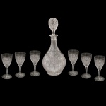 Conjunto em cristal tcheco lapidado, que faz parte de um conjunto tradicional de Cristal da Boêmia, composto por 1 garrafa licoreira e seis cálices. Corpo bojudos e formato piriforme ornamentado com cortes geométricos profundos e uma tampa esférica facetada que acompanha o mesmo padrão de lapidação. Este modelo apresenta o clássico padrão de lapidação intrincada conhecido internacionalmente como 500PK, caracterizado por desenhos rendados e detalhes em formato de estrela ou floco de neve esculpidos à mão, reconhecido por seu alto índice de refração, brilho e sonoridade. 15 x 6 cm licoreira.