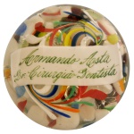 Peso para papel, de formato semiesférico em cristal transparente. Apresenta decoração interna policromada com adornos florais estilizados e faixa com o nome de Armando Aosta Dr. Cirurgião Dentista. 7 x 10 cm.