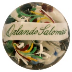 Peso para papel, de formato semiesférico em cristal transparente. Apresenta decoração interna policromada com adornos florais estilizados e faixa com o nome de Orlando Salomão. 7 x 9 cm.