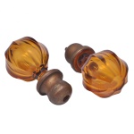 Par de pinhas decorativas em cristal lapidado na cor âmbar com base de bronze rosqueável. Corpo superior em cristal com lapidação em gomos (canelada) .Tom âmbar translúcido de forte refração luminosa. Base de metal possui uma rosca interna na extremidade inferior. 14 x 7 cm.